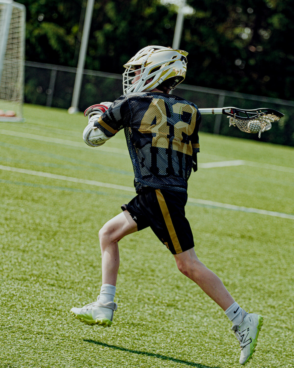 A club lacrosse player sprinting upfield.